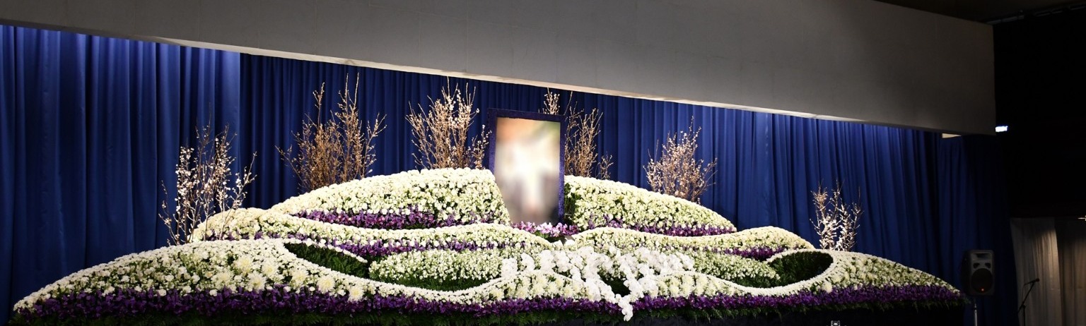 白と紫の花を流れる曲線に仕立てた花祭壇