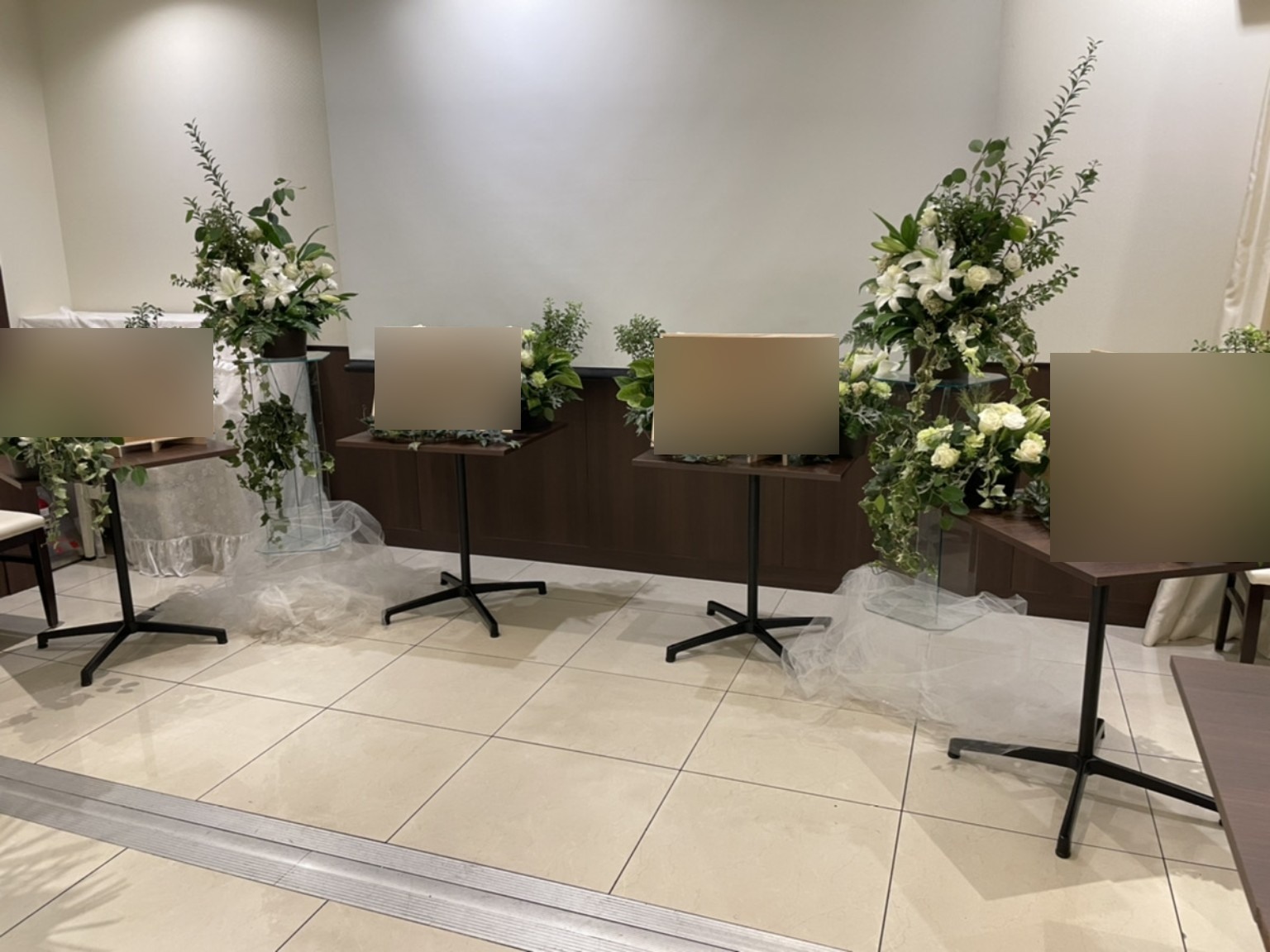 思い出の写真ボードを白と緑の花で囲んだ展示