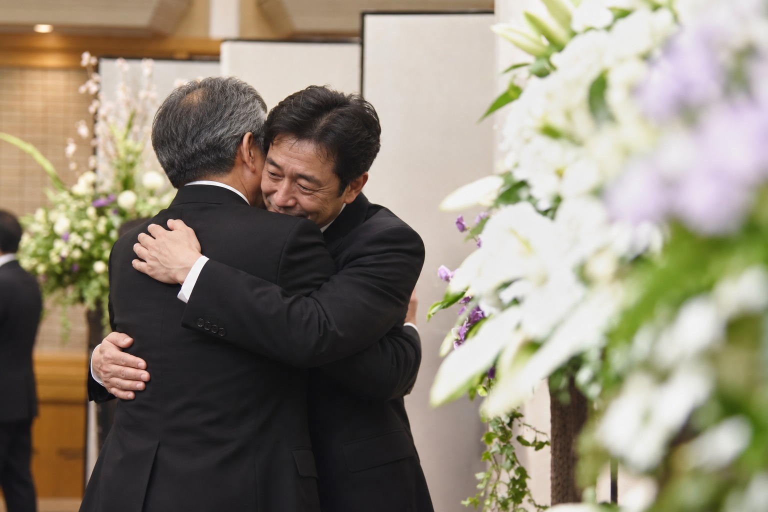再会した男性同士が抱き合い、喜びと悲しみを分かち合う生成イメージ